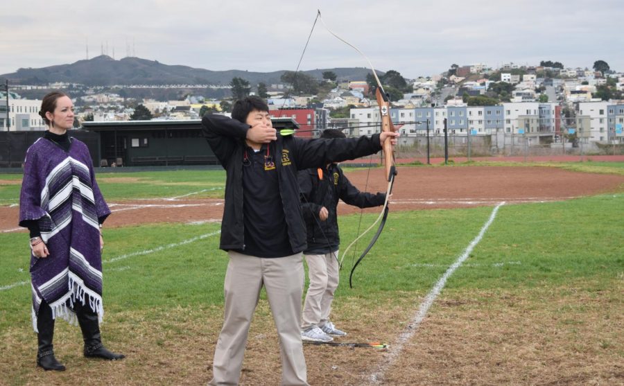 Student Kyle Pan ’21 takes aim while archery teacher Colleen O’Rourke carefully monitors his technique.