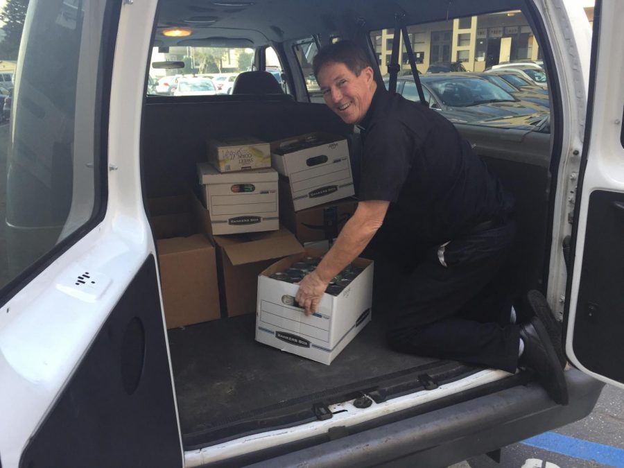 Father John Jimenez loads boxes of donated food into a
van and prepares them for delivery to those in need. 
