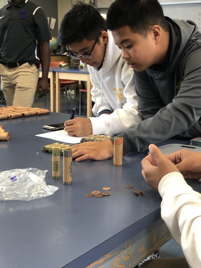 CORE team members CJ Cabanero ’21 and Aysaiah Radoc Manrique ’21 count coins collected for the annual Billy Choy AIDS Penny Drive.