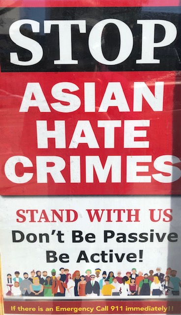A sign in the window of a business on Ocean Avenue encourages people to stand together against hate crimes. 