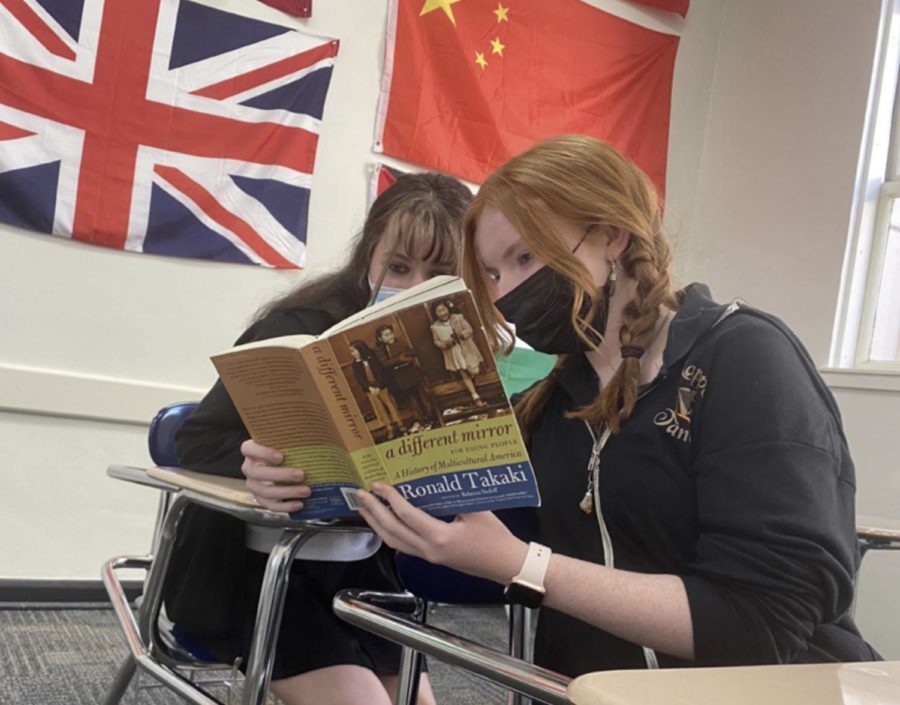 Terry Delaney-Parish ’24 and Rachel Kavanagh ’24 read A Different Mirror for Global and Ethnic Studies class at Riordan.