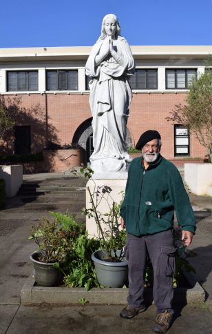 Reno Taini ’59 stands in front of the statue his father saved.
