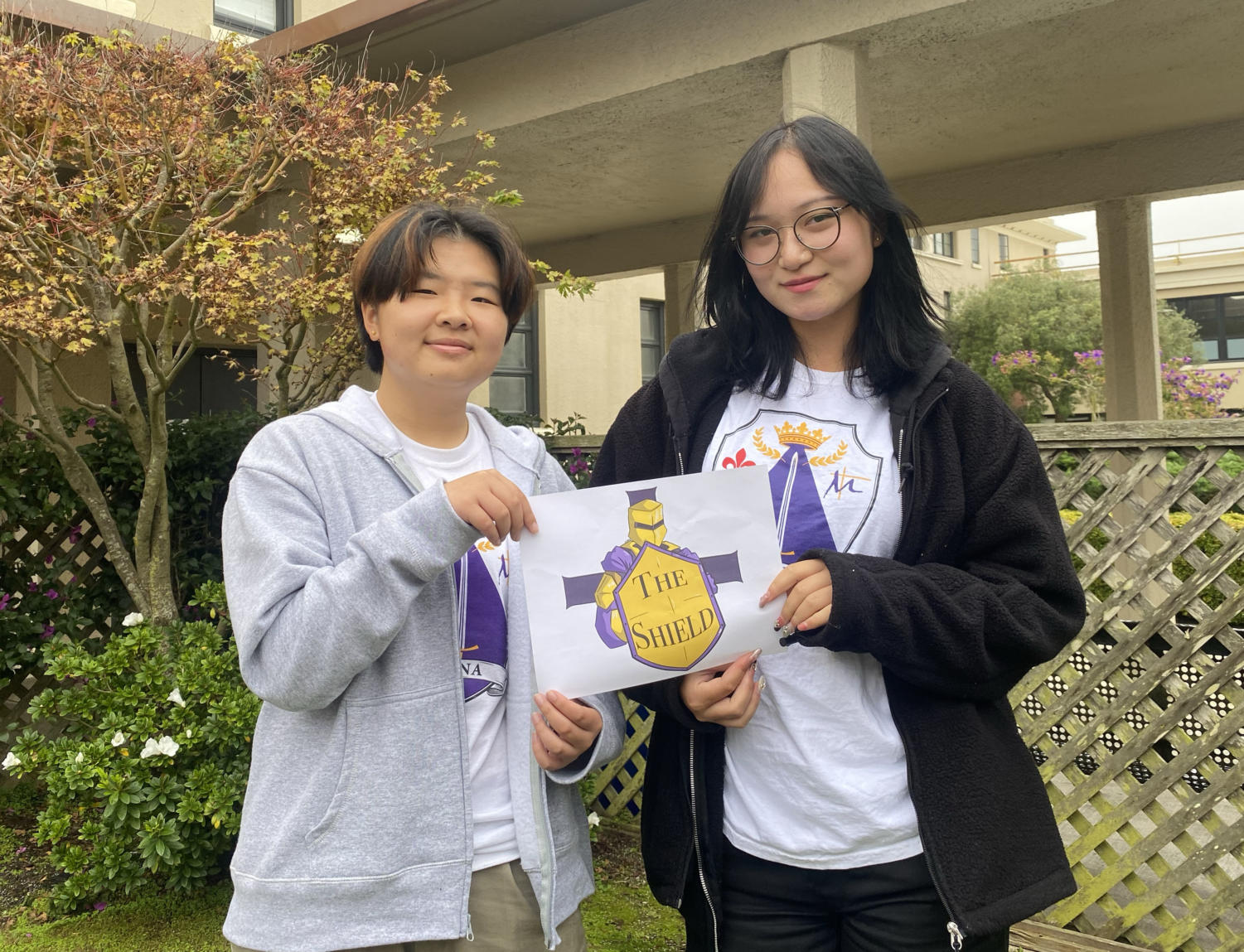 Artist Vee Chen '25 and Editor-in-Chief Angelina Ning '23 display Chen's logo design for The Shield. 