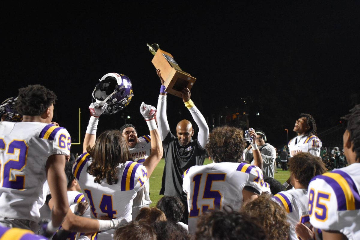 Coach Adhir Ravipati holds up the Stanfel Cup after the Crusaders defeated SHC on Nov. 3. 