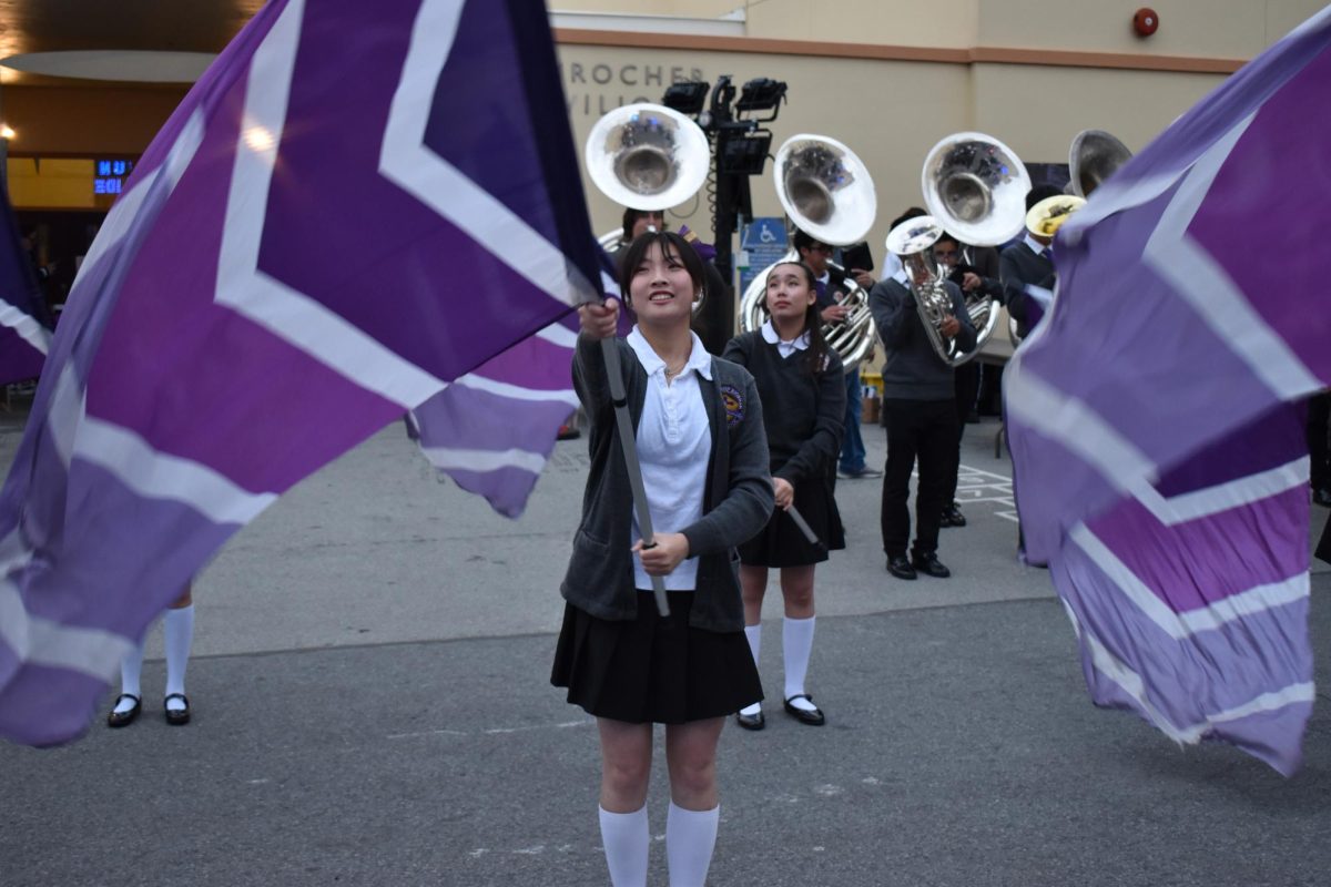 Katelyn Leong ’25 performs with the Riordan Color Guard and Marching Band at the St. Cecilia School Festival. 