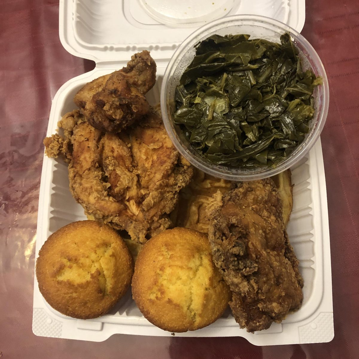 Take-out container filled to the brim with soul food staples.