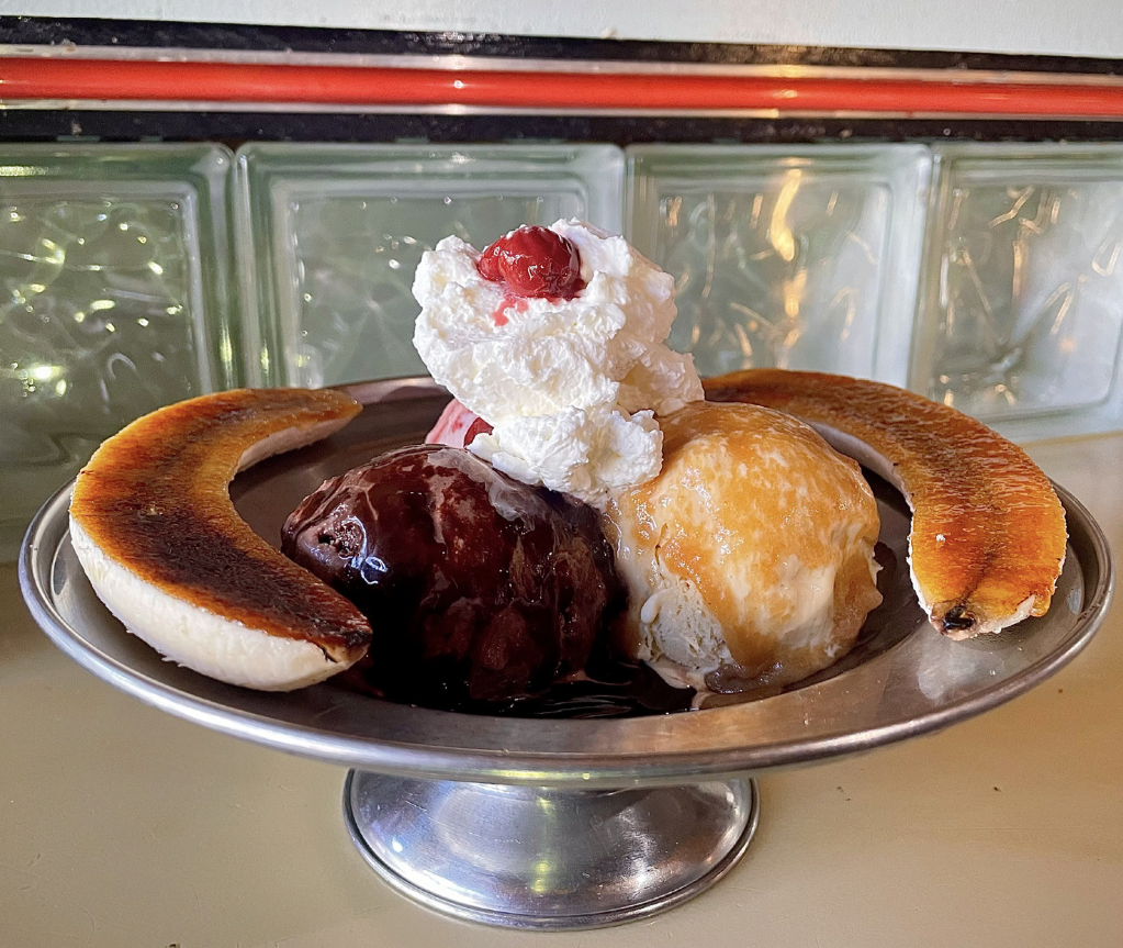 A trio of ice cream scoops adorned with toppings, served on a silver platter.
