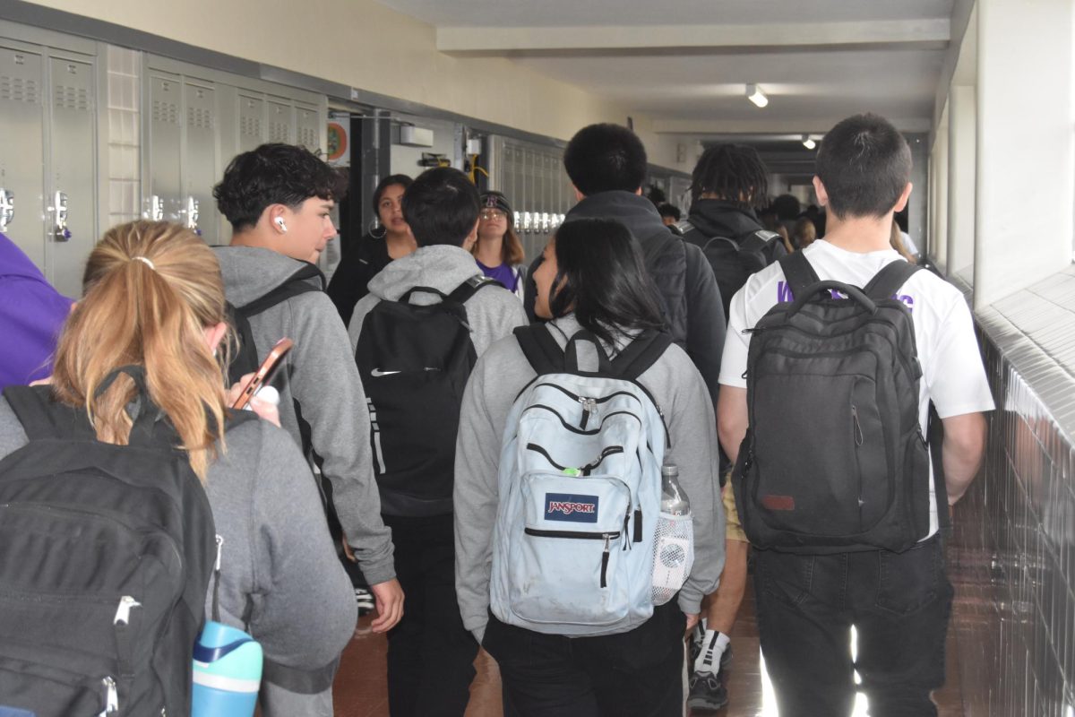 Students leave classroom on the second floor and walk down the hallway. 