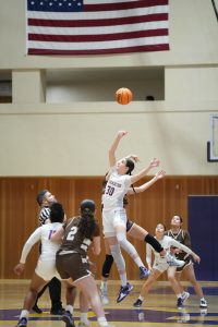 Tara Dacic ’25 jumps for the ball in a home game on Kevin Restani Court.