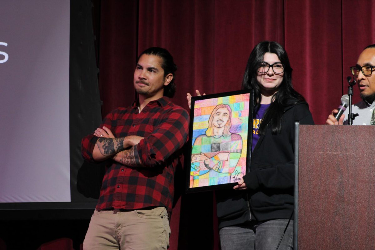 Elena Navarro '26 presents Randy Ribay with a gift from the Art Club. 