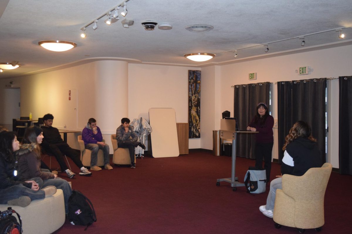 Religion Department Chair Danielle Jow teaches OCIA in the theater lobby.