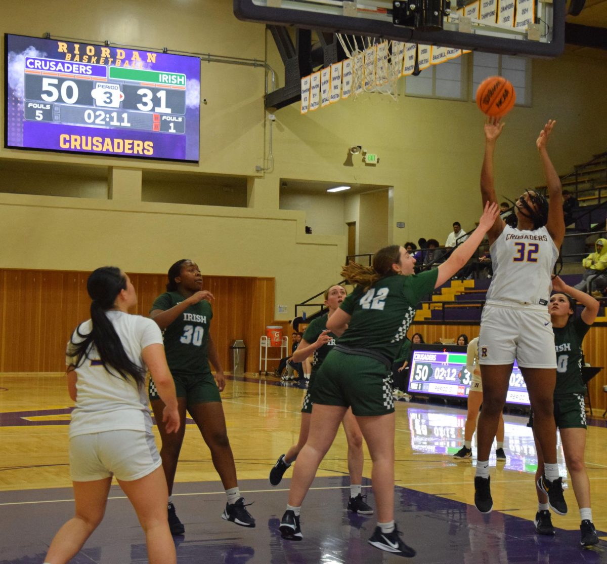 Forward Zion McGuire '26 fights for a basket through multiple SHC defenders in a recent home game. 