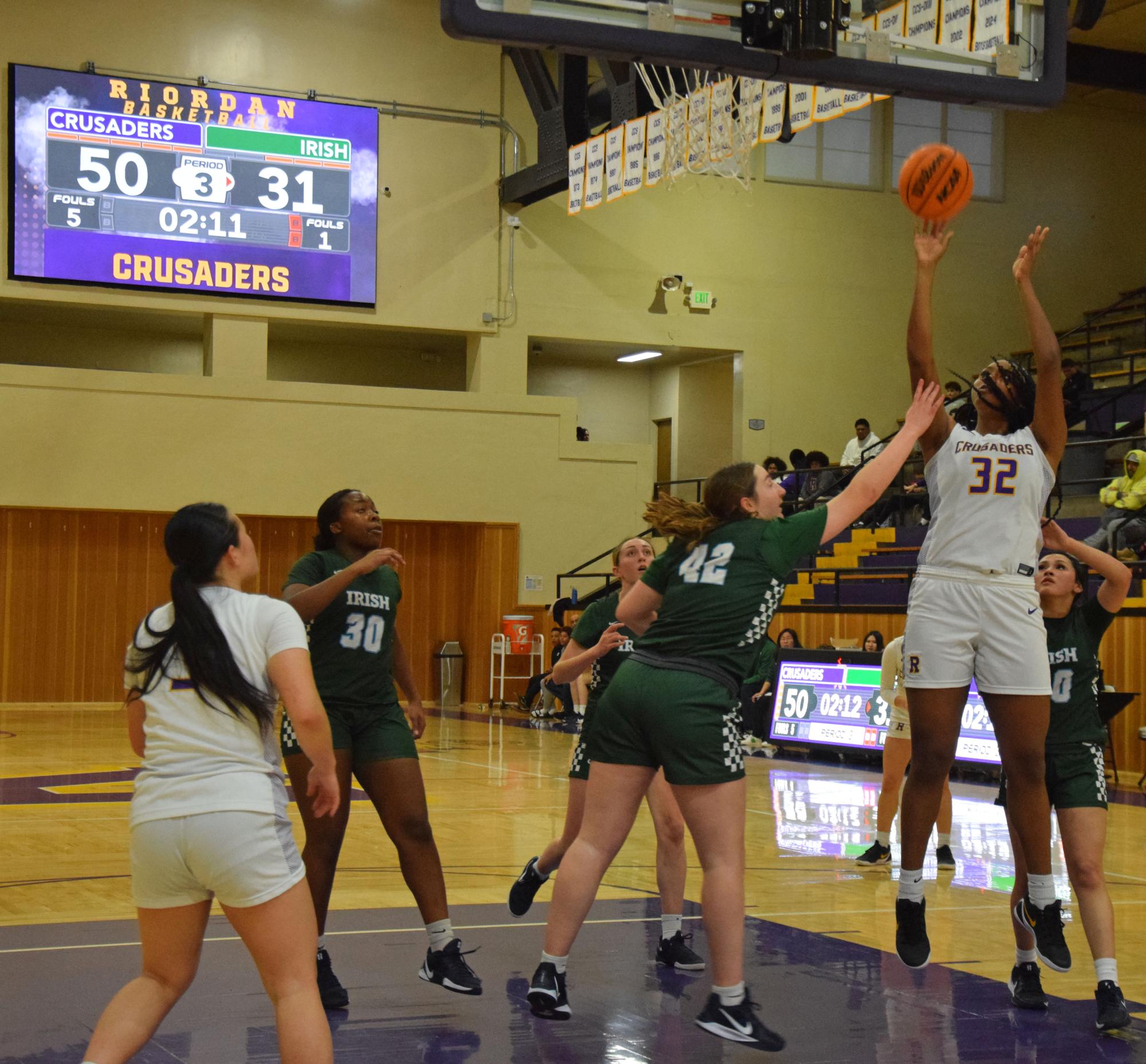 Forward Zion McGuire '26 fights for a basket through multiple SHC defenders in a recent home game. 