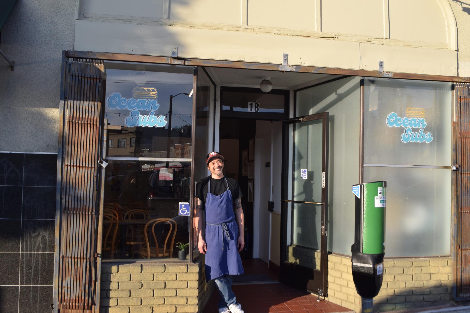 Lee Opelinia '95 stands in the doorway of his restaurant, Ocean Subs, awaiting hungry customers. 