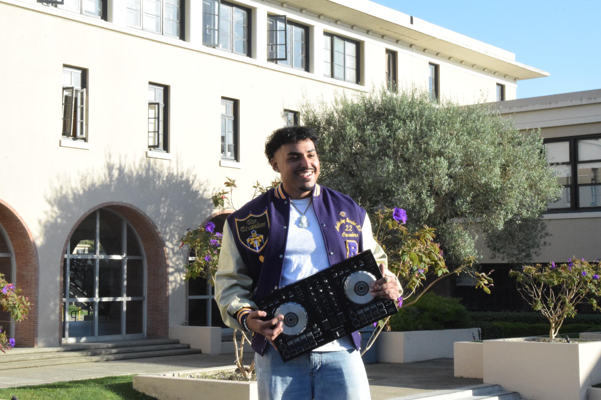 Grayson Salomon ’22 poses with DJ equipment in Riordan’s courtyard.