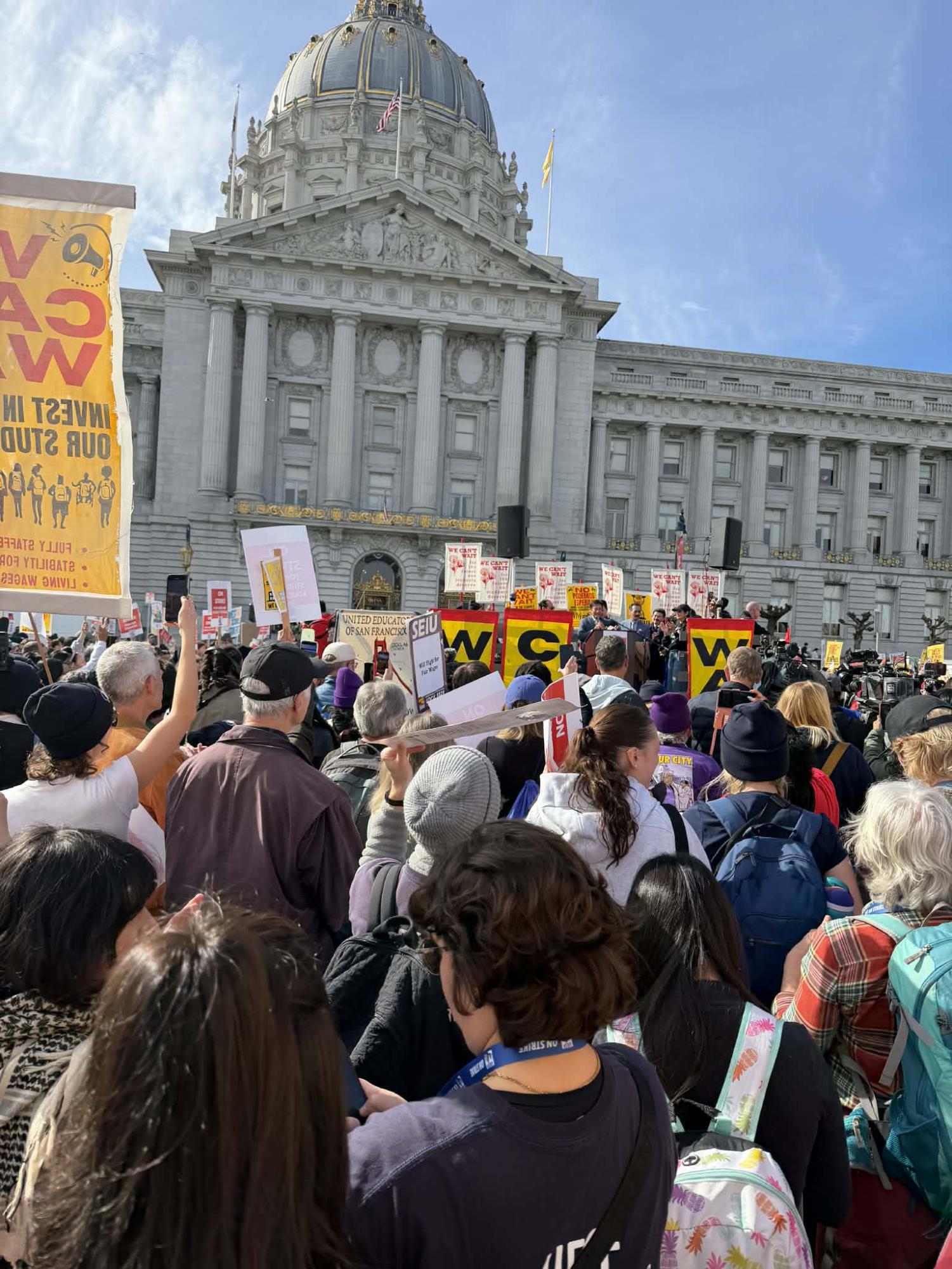 Public school teachers and union members gather outside City Hall to protest.