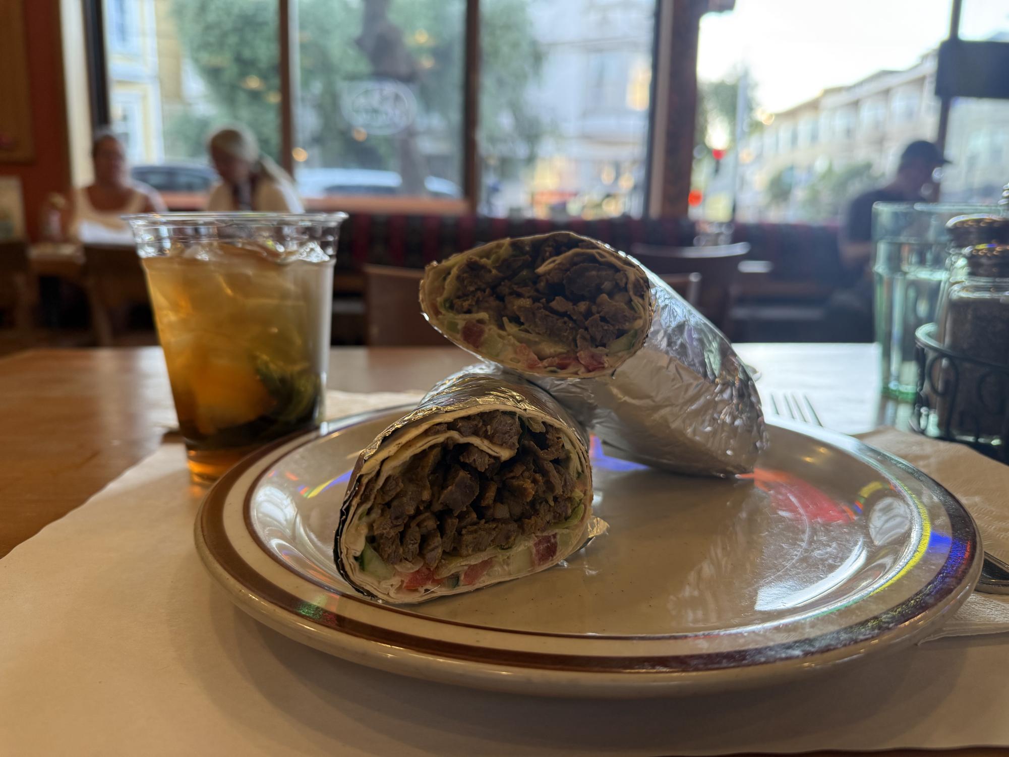 A shawarma filled with beef and lamb accompanied by golden brown mint tea.